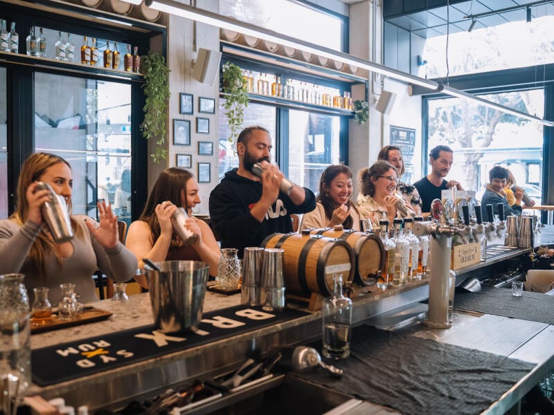 A group of colleagues shake cocktails at a class